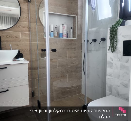 מקלחון זכוכית עם מוצרי טיפוח על מדף